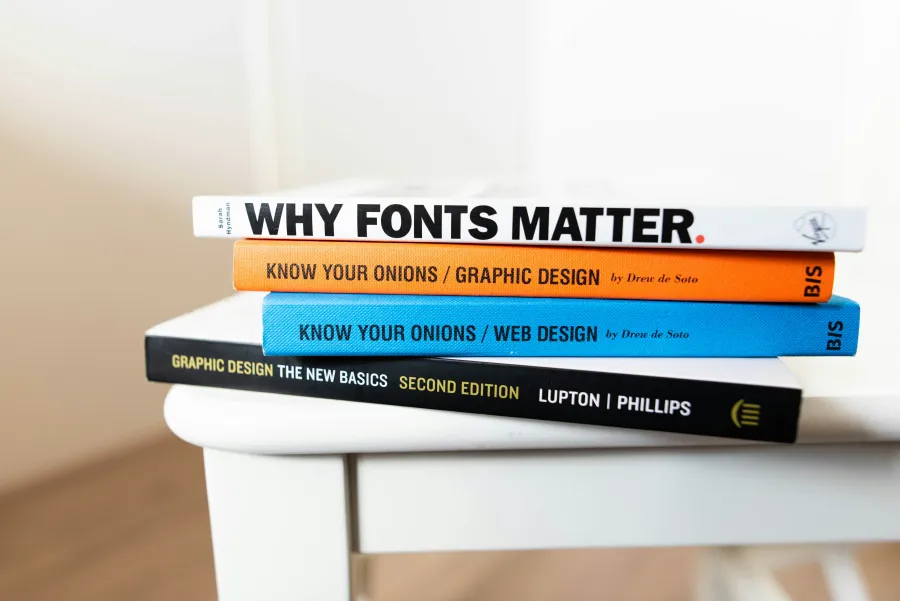 Some books are arranged on a table. The one on the top says in the cover "Why Fonts Matter".