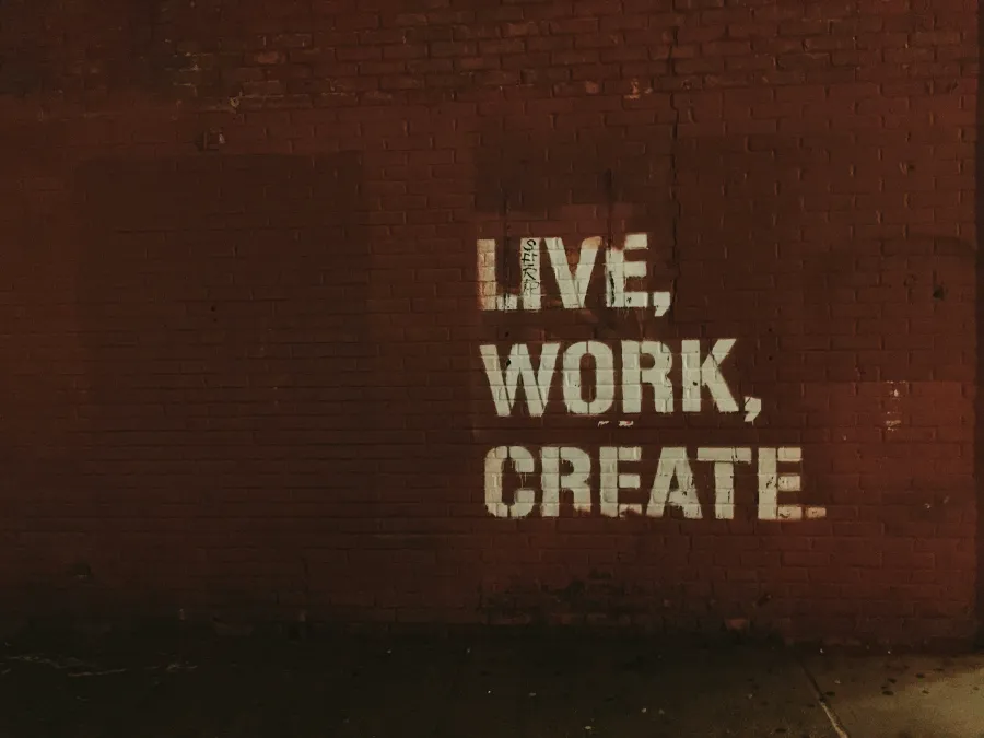 A brick wall with the words Live, Work, Create